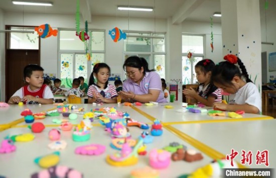 在肥西縣山南鎮(zhèn)中心幼兒園，孩子們?cè)诶蠋煹闹笇?dǎo)下做彩色泥塑。陳家樂 攝