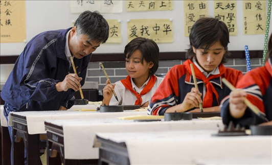 △新疆疏附縣托克扎克鎮(zhèn)中心小學書法教室內(nèi)，同學們正在學習寫毛筆字。