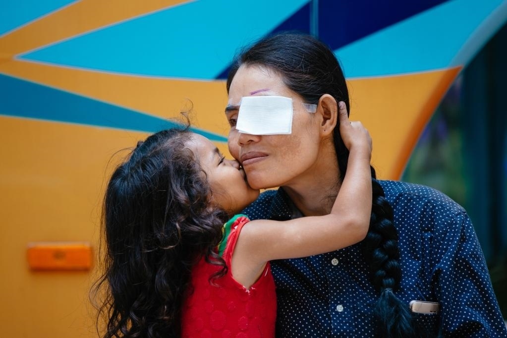 2019年3月15日，在柬埔寨磅湛省醫(yī)院，即將接受白內(nèi)障手術(shù)的患者孫美樂(lè)接受女兒的親吻祝福。在接受了中國(guó)醫(yī)療隊(duì)的白內(nèi)障義診手術(shù)后，她的視力逐步恢復(fù)，生活有了新的光明和希望。