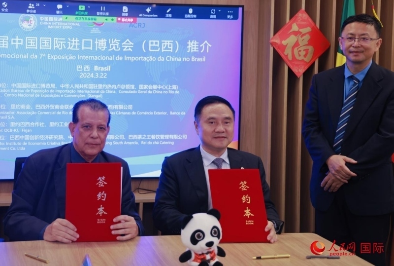 巴西外貿(mào)商會(huì)聯(lián)合會(huì)會(huì)長(zhǎng)阿代爾·羅伯托（左）與中國(guó)國(guó)際進(jìn)口博覽局副局長(zhǎng)吳政平（中）現(xiàn)場(chǎng)簽訂協(xié)議。人民網(wǎng)記者 宋亦然攝