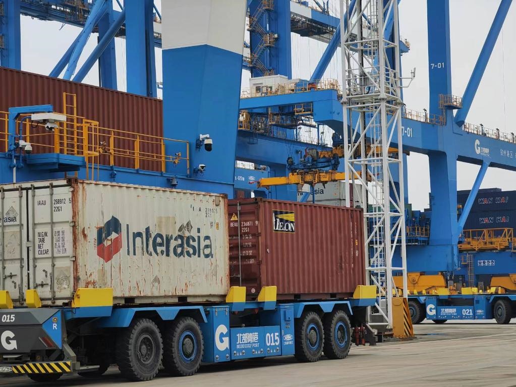 在欽州自動(dòng)化集裝箱碼頭，智能導(dǎo)引運(yùn)輸車在運(yùn)送集裝箱。新華社記者趙歡 攝