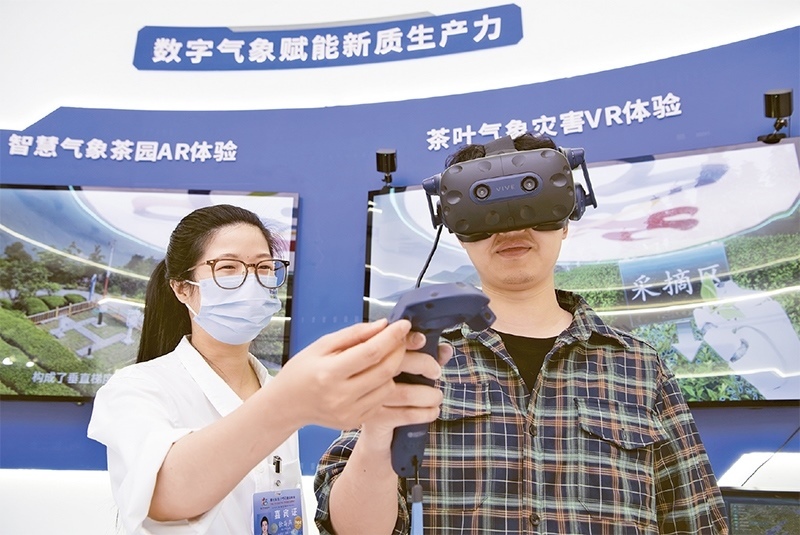 2024年5月23日，第七屆數(shù)字中國(guó)建設(shè)峰會(huì)現(xiàn)場(chǎng)體驗(yàn)區(qū)在福州海峽國(guó)際會(huì)展中心向?qū)I(yè)觀眾開(kāi)放。本次現(xiàn)場(chǎng)體驗(yàn)區(qū)圍繞本屆峰會(huì)主題“釋放數(shù)據(jù)要素價(jià)值，發(fā)展新質(zhì)生產(chǎn)力”，設(shè)置“數(shù)字惠民”、“數(shù)字能力”、“數(shù)字基礎(chǔ)”、“數(shù)字生態(tài)”、“數(shù)字賦能”五大板塊。圖為一名觀眾（右）在數(shù)字氣象賦能新質(zhì)生產(chǎn)力展臺(tái)上進(jìn)行體驗(yàn)。 新華社記者 魏培全/攝