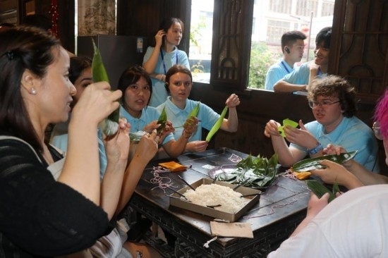 6月9日，美國(guó)青年代表在重慶永川松溉古鎮(zhèn)體驗(yàn)包粽子。新華社記者 周思宇 攝