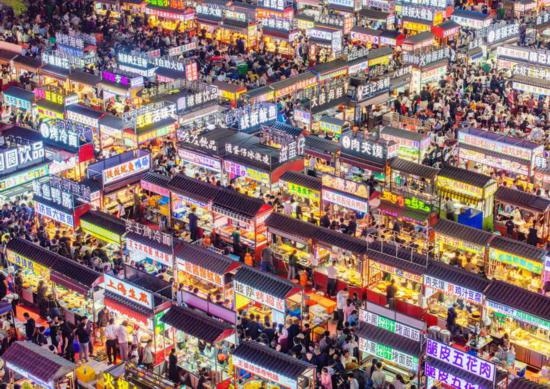 2024年4月21日，人們?cè)诤颖笔≌h小商品夜市品嘗美食（無人機(jī)照片）。新華社發(fā)（武志偉 攝）