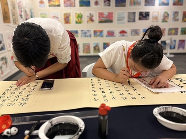 參加本次展覽的青少年在現(xiàn)場進行書法創(chuàng)作。主辦方供圖