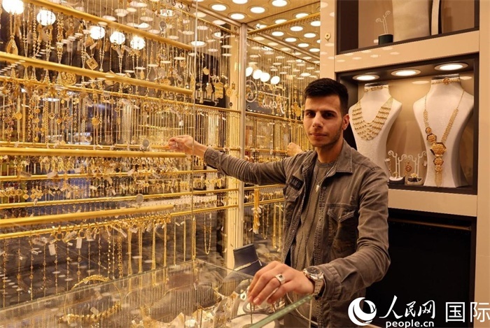 一名銷售員展示黃金飾品。人民網(wǎng) 伊納斯·易卜拉欣攝