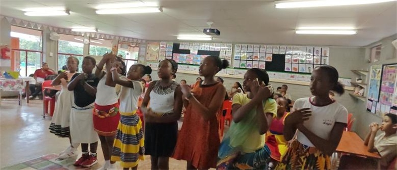 南非學(xué)生展示民族服飾，合唱《聽我說謝謝你》。
