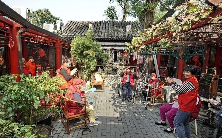 2024年10月12日，鐘樓灣胡同的老年人在社區(qū)內(nèi)的四合院養(yǎng)老驛站休閑。2017年起，北京市先后開展了兩輪背街小巷環(huán)境整治提升行動(dòng)，完整保留了中軸線生活建筑群的歷史信息，并根據(jù)居民的生活和居住方式進(jìn)行適配化的更新和改造，極大地改善了生活環(huán)境。2023年鐘樓灣胡同被評(píng)為“北京最美街巷”。