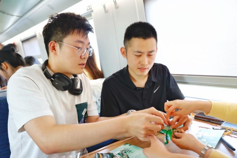 G232次旅客親手制作端午荷包和五彩繩。王磊攝